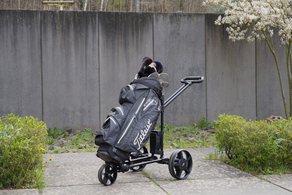 Electrically assisted golf caddy with WELLGO drive and sensor handle